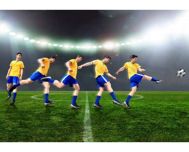 Zeitlupenansicht eines schießenden Fußballers, aufgenommen in einem Stadion mit dramatischer Beleuchtung.