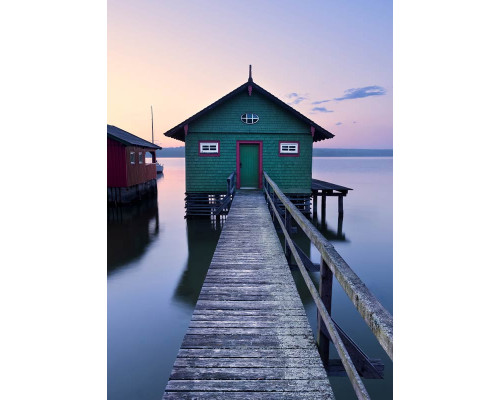 Bootshaus grün Fototapete, mit einer malerischen Hütte am Wasser.