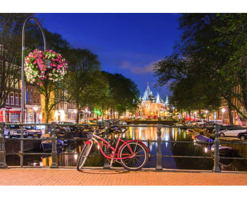 Fototapete mit rotem Fahrrad auf einer Amsterdamer Brücke bei Nacht, umgeben von beleuchteten Grachtenhäusern und ruhigen Grachten.