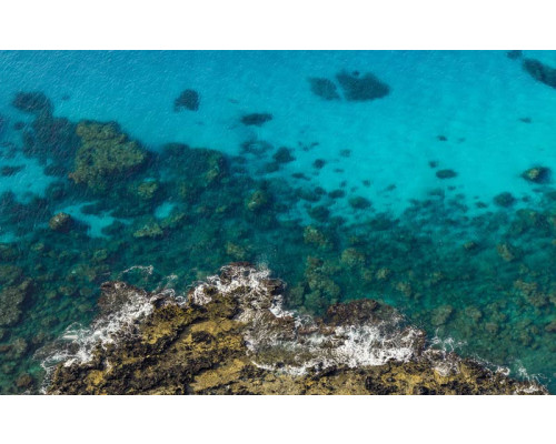 Klares blaues Meer mit atemberaubender Aussicht auf die Landschaft.