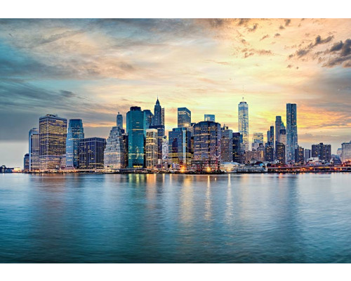 Fototapete New York Skyline bei Sonnenuntergang mit Wolkenkratzern und Spiegelung im Wasser.