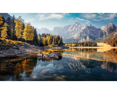Gelassenheit strahlt diese Fototapete aus, die einen von dichten Wäldern und Bergen umgebenen Bergsee zeigt.