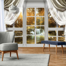 Eine Fototapete eines Herbstwaldes mit Wasserfall durch ein Fenster, geeignet für das Wohnzimmer.