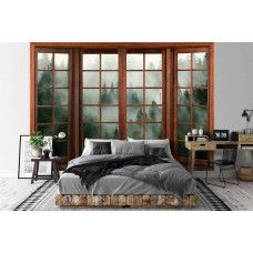 Eine Fototapete mit 3D-Fensterblick auf einen nebligen Wald in einem stimmungsvollen Schlafzimmer.