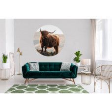 Ein Tapetenkreis mit einem schottischen Highlander in einer Berglandschaft, perfekt für ein Wohnzimmer.