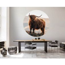 Ein Tapetenkreis mit einem majestätischen schottischen Highlander in einer ruhigen Berglandschaft, besonders für ein Wohnzimmer.