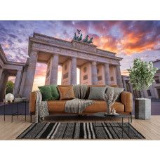Fototapete Brandenburger Tor im warmen Abendlicht im Wohnzimmer mit ikonischem Wahrzeichen und orange-rosafarbenen Wolken.