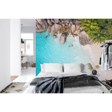 Eine tropische Fototapete mit einem sonnenüberfluteten Strand und Palmen, perfekt für ein Schlafzimmer.