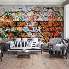 Eine industrielle Fototapete mit einer mit Blumen bemalten Ziegelwand im Wohnzimmer.