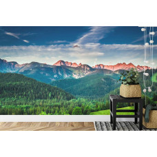 Eine Fototapete mit der majestätischen Schönheit einer von Wäldern umgebenen Berglandschaft, ideal für ein Wohnzimmer.