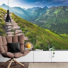 Eine Fototapete mit einem malerischen Bergpfad entlang imposanter Berge, ideal für ein Wohnzimmer.