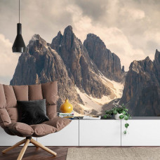 Eine Fototapete mit Panoramablick auf Berggipfel und Felsen, ideal für ein Wohnzimmer.