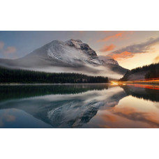 Fototapete eines bezaubernden Bergsees, umgeben von Bergen und Wäldern, das eine friedliche und ruhige Atmosphäre ausstrahlt.