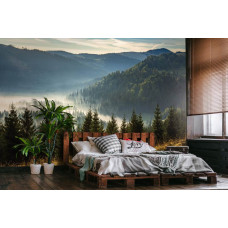 Eine Fototapete mit einer Berglandschaft mit Bäumen und mystischem Nebel, ideal für ein Schlafzimmer.