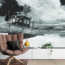 Eine Fototapete mit einem idyllischen Strand mit einem Boot und ruhigen Wellen, ideal für ein Wohnzimmer.