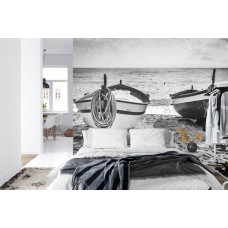 Eine Fototapete mit einer stimmungsvollen Strandszene mit Booten an einem ruhigen Meer, geeignet für ein Schlafzimmer.