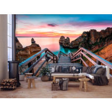 Eine Fototapete von einer 3D-Brücke zum Strand mit Blick auf das Meer und Felsen in einem stilvollen Wohnzimmer.