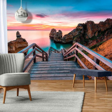 Eine Fototapete von einer Brücke zum Strand mit 3D-Design im Vliesbehangstil für ein Wohnzimmer.