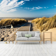 Eine Fototapete mit einer Strandlandschaft mit Dünen und Meer, die eine entspannende Atmosphäre in einem Wohnzimmer schafft.