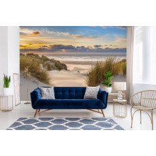 Fototapete mit den Dünen an der Nordsee mit einem weiten Strand und einem atemberaubenden Sonnenuntergang, in warmen Farben in einem Wohnzimmer.