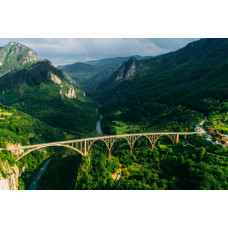 Die Durdevica Tara-Brücke in Montenegro, umgeben von den Tara-Bergen und abgebildet auf einer Fototapete mit einer Berglandschaft.