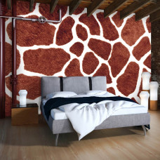 Eine Fototapete mit dem Muster einer Giraffenhaut im Vliestapetenstil für ein Schlafzimmer.