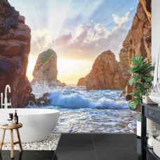 Eine Fototapete mit einem spektakulären Bild von Wellen zwischen Felsen und Bergen, ideal für ein Badezimmer.