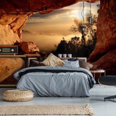 Fototapete mit Blick aus einer Höhle auf einen nebligen Wald mit 3D-Effekt, ideal für ein ruhiges Schlafzimmer.