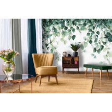 Fotobehang met sierlijk hangende bladeren in groentinten aan de muur van een frisse woonkamer.