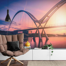 Eine Fototapete mit der Unendlichen Brücke vor einem farbenfrohen Sonnenuntergang, angezeigt in einem Wohnzimmer.
