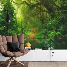 Eine Fototapete mit einem Dschungel mit tropischer Flora und einem See, abgebildet in einem Wohnzimmer.