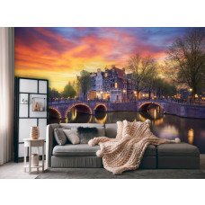 Ein Wohnzimmer mit einer Fototapete von alten Herrenhäusern an der Ecke der Keizersgracht und Leidsegracht in Amsterdam, mit beleuchteten Brücken, die den Abend erhellen.