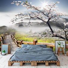 Eine Fototapete mit einer Frühlingslandschaft mit Bergen und Bäumen, zu sehen im Wohnzimmer und Schlafzimmer.