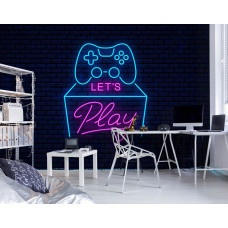 Fototapete „Let’s Play Gaming Neon“ in einem Gaming-Zimmer mit Neon-Gamecontroller und bunten Schriftzügen vor einem dunklen Backsteinhintergrund.