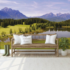 Eine Fototapete von einem See in den Bergen mit Wald und Bäumen auf dem Display im Wohnzimmer.