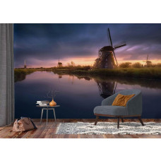 Ein Fototapet von Mühlen bei Sonnenuntergang entlang eines Flusses in einem Büro.