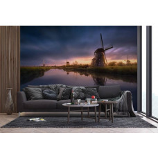 Ein Fototapet von Mühlen bei Sonnenuntergang entlang eines Flusses in einem Wohnzimmer.