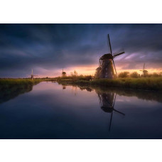 Ein Fototapet von Mühlen bei Sonnenuntergang entlang eines Flusses.