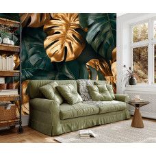 Fototapete mit großen Monstera Blättern und goldenen Details in einem modernen Wohnzimmer.
