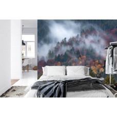 Eine Fototapete mit einer nebligen Bergoase und in Morgennebel gehüllten Bergen in einem Schlafzimmer.