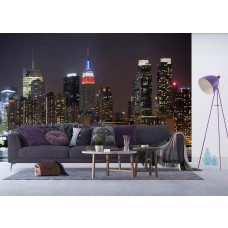 Ein Wohnzimmer mit einer Fototapete der New Yorker Skyline bei Nacht und den beleuchteten Wolkenkratzern.