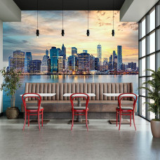 Fototapete mit New Yorker Skyline-Panorama bei Sonnenuntergang in einem Restaurant mit moderner Stadt und warmen Himmelsfarben.