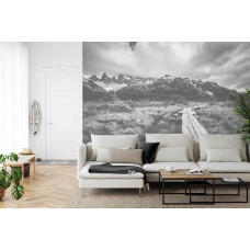 Eine Fototapete mit einer stimmungsvollen Straße durch eine Berglandschaft, perfekt für ein Wohnzimmer.