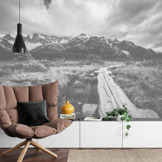 Eine Fototapete mit einer kurvenreichen Straße, die zu hohen Bergen führt, perfekt für ein Wohnzimmer.