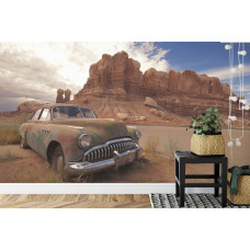 Eine einzigartige Fototapete eines alten Autos in einer Wüstenlandschaft mit Felsformationen, ideal für ein Schlafzimmer.