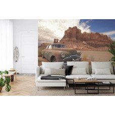 Eine beeindruckende Fototapete eines alten Autos in einer Wüste mit natürlichen Elementen, geeignet für ein Wohnzimmer.