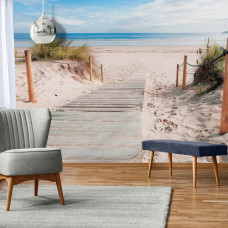 Eine Fototapete mit einem Weg zum Strand mit Meer und Dünen, schön in einem hellen Wohnzimmer.