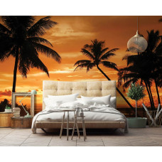 Eine Fototapete mit Palmen bei einem farbenfrohen Sonnenuntergang im Schlafzimmer.