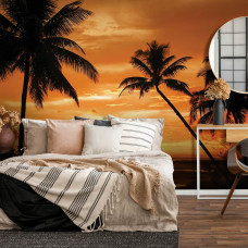 Eine Fototapete mit Palmen in Silhouette vor einem farbenfrohen Sonnenuntergang.