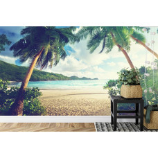 Eine Fototapete mit Palmen an einem tropischen Strand an einem ruhigen Meer, abgebildet in einem Schlafzimmer.